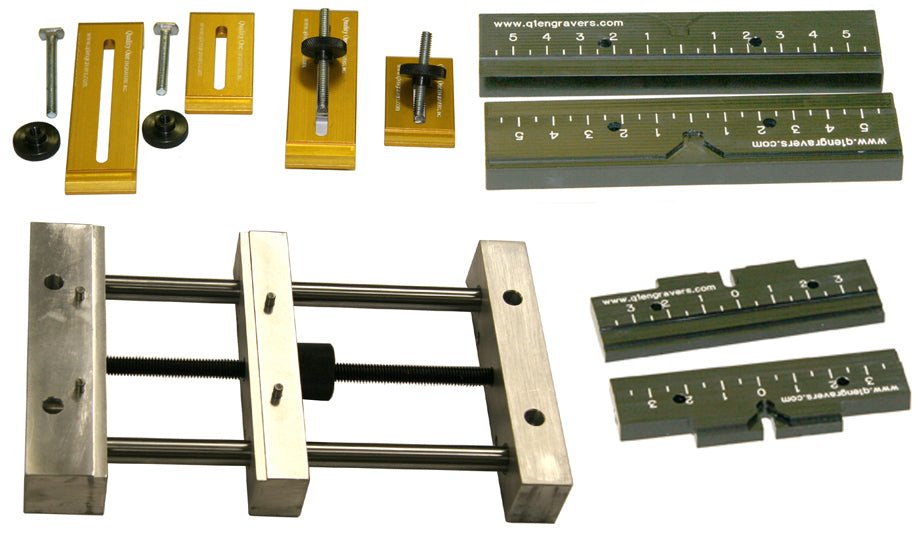 Clamping fixtures for holding work on an engraving table.