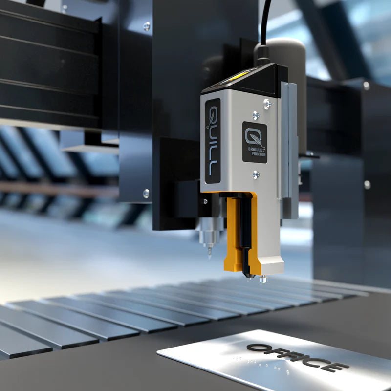 A rotary engraving cutter cutting a plate on an engraving machine table.